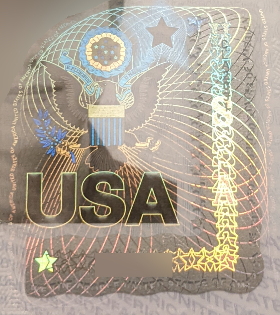 Iridescent colors reflect off of a hologram of the coat of arms of the United States.